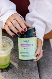 Front view of a Nueday Wellness supplement jar labeled “Debloat Me,” a daily gut health support supplement designed to relieve bloating and support digestion. 